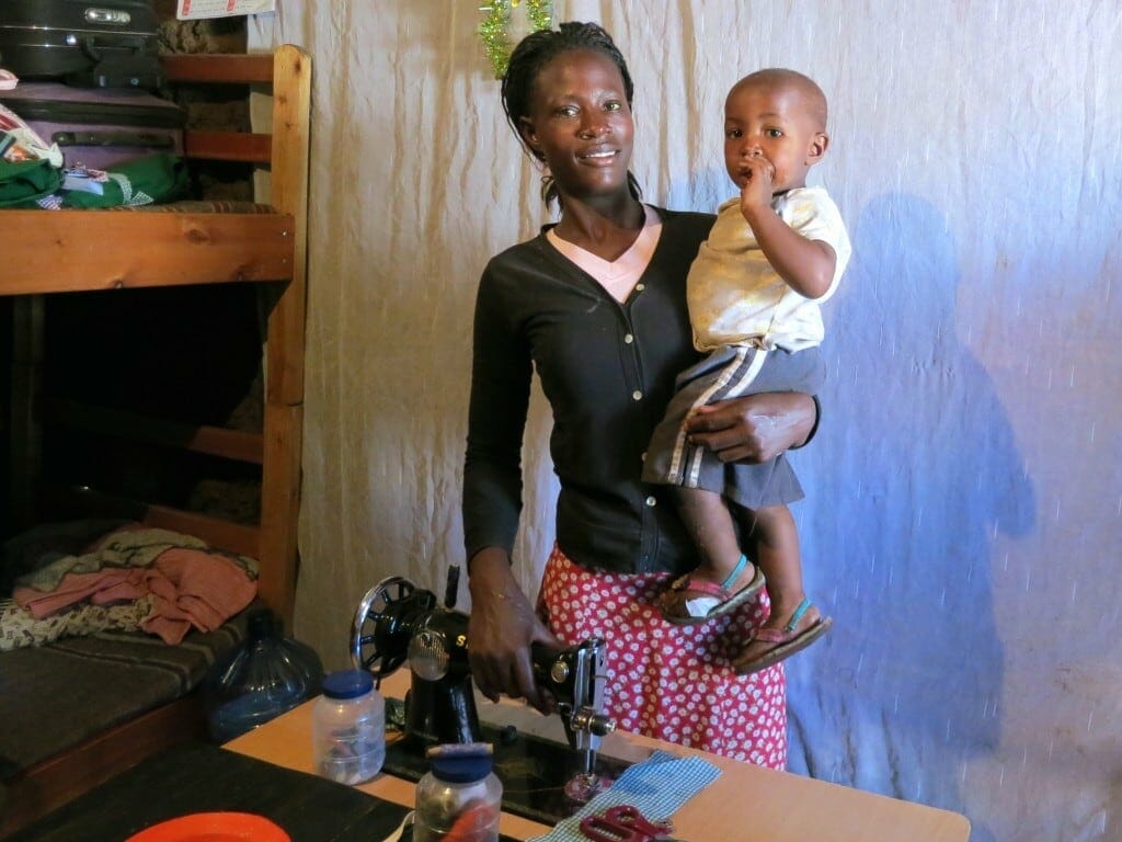 Lillian with her son Ray and the sewing machine she bought with her loan!